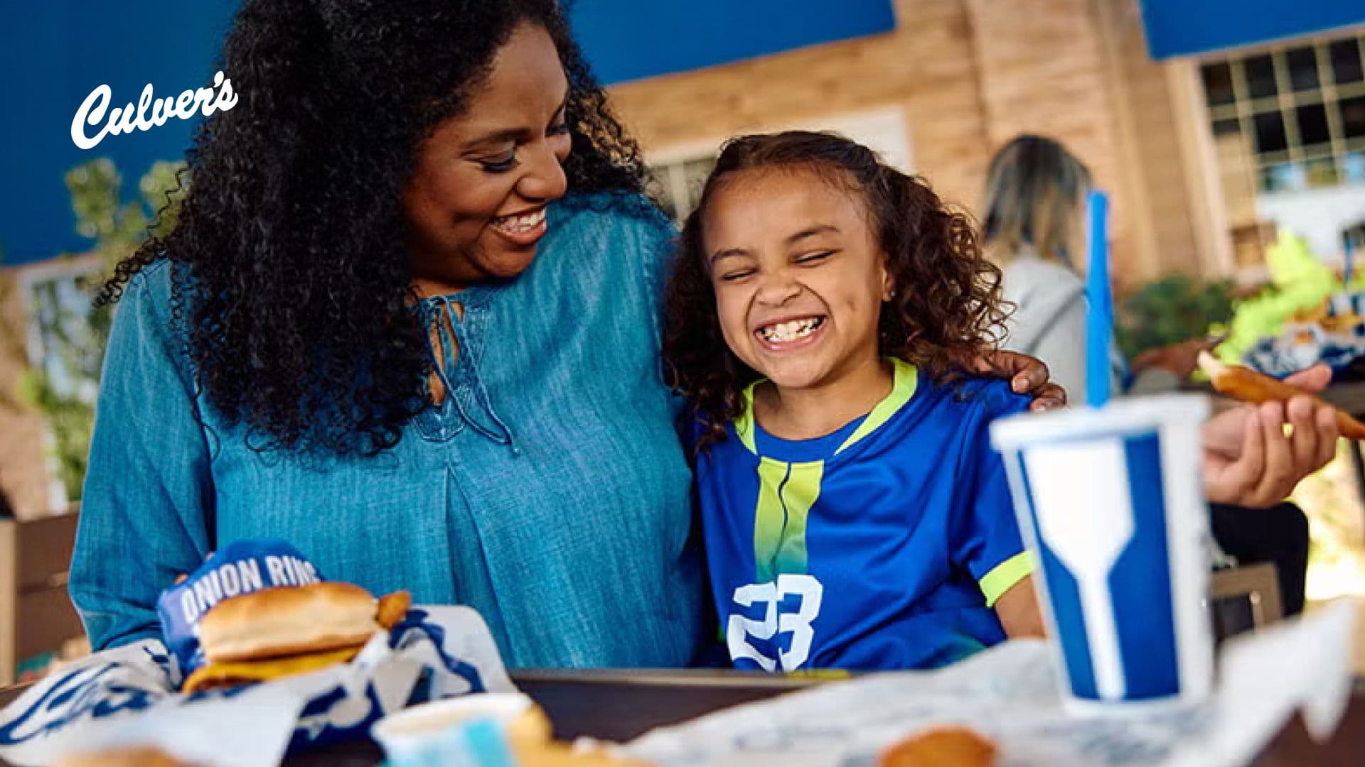 Woman and child laughing at restaurant table