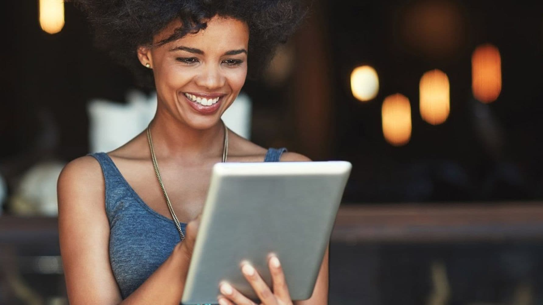 A lady using a tablet while smiling