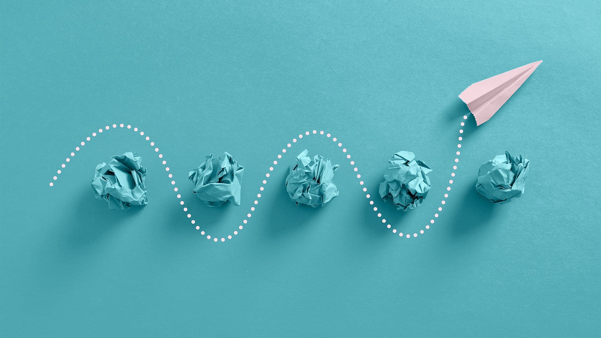 Paper airplane navigating through paper balls