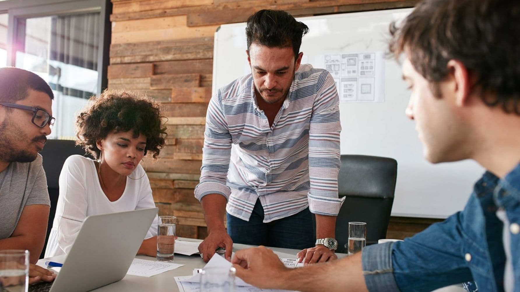 four people in a meeting discussing on the table.