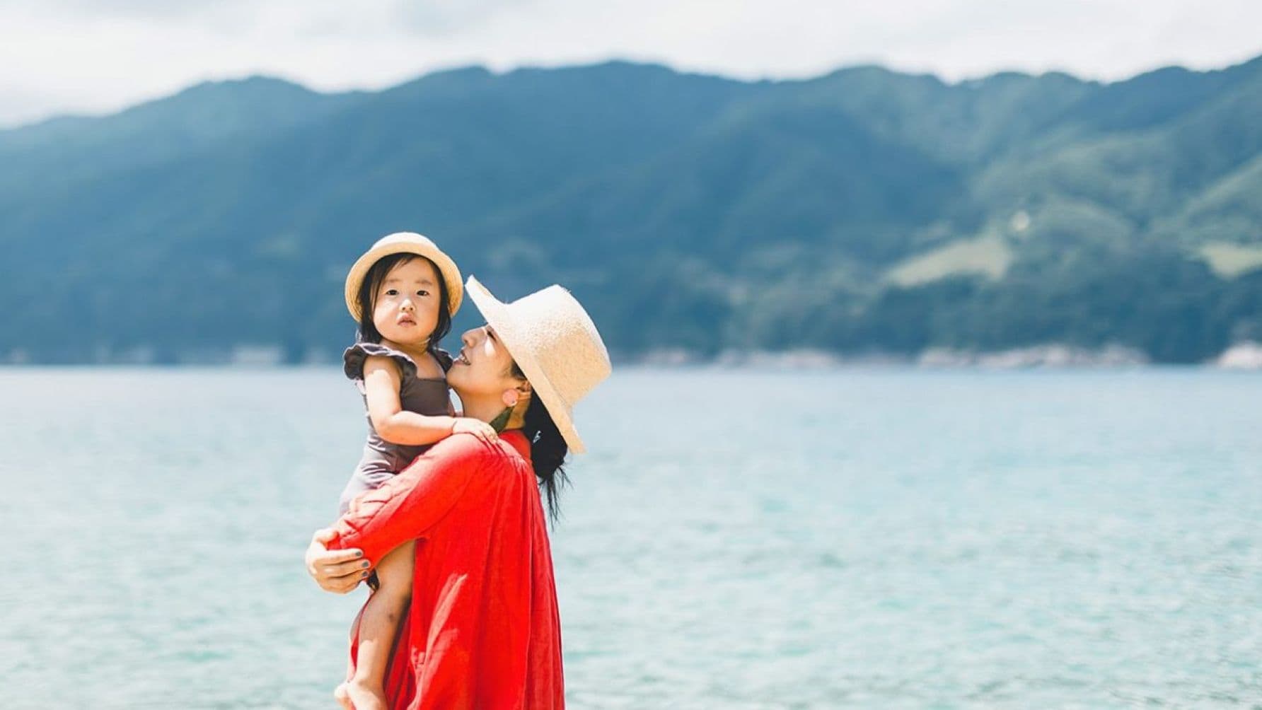 woman carrying a baby along the river