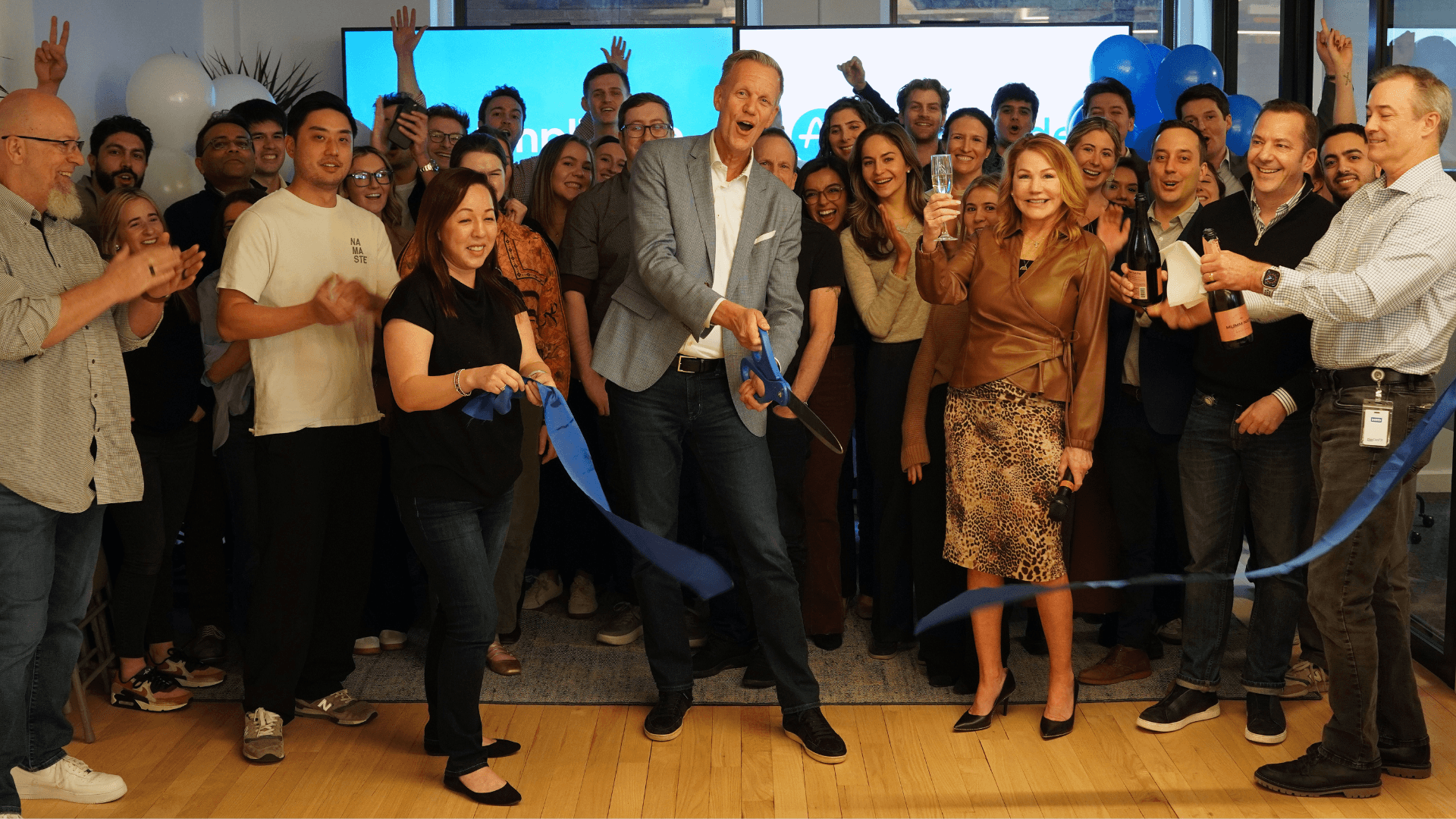 Thomas Hansen and the rest of the Amplitude NY office cut a ribbon and pop champagne