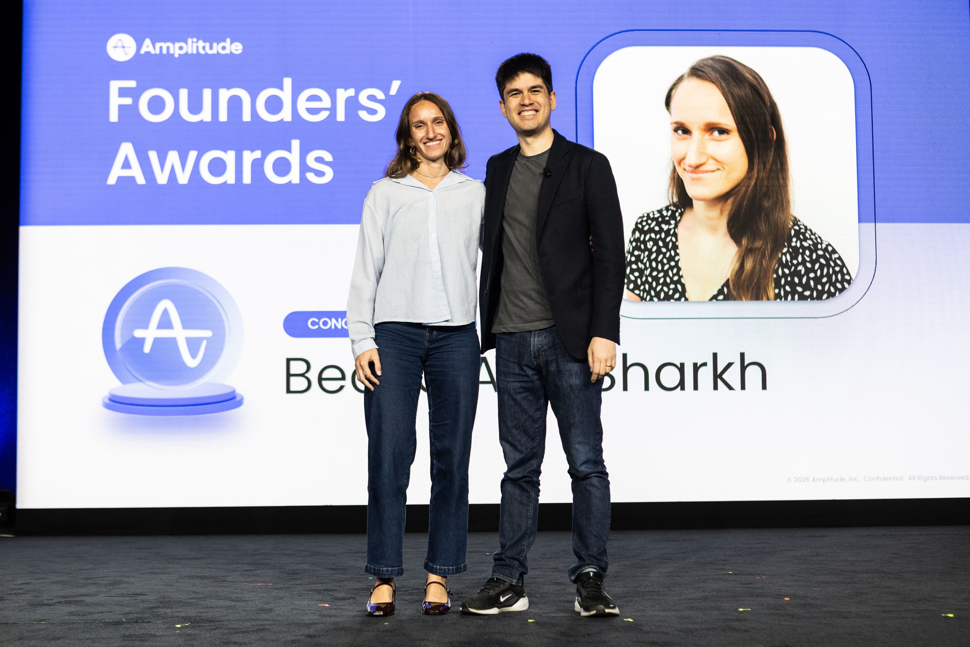 Becca Abu Sharkh with Amplitude CEO Spenser Skates on stage acknowledging her 2025 Founders' Award.