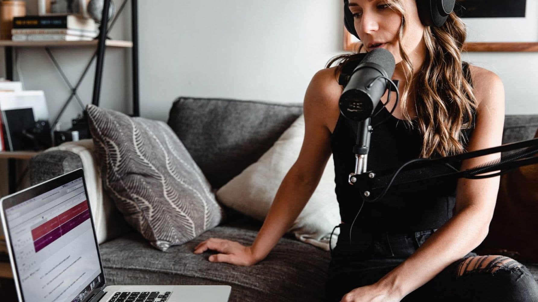Tech-savvy woman multitasking between managing production on her laptop and with her pet mic