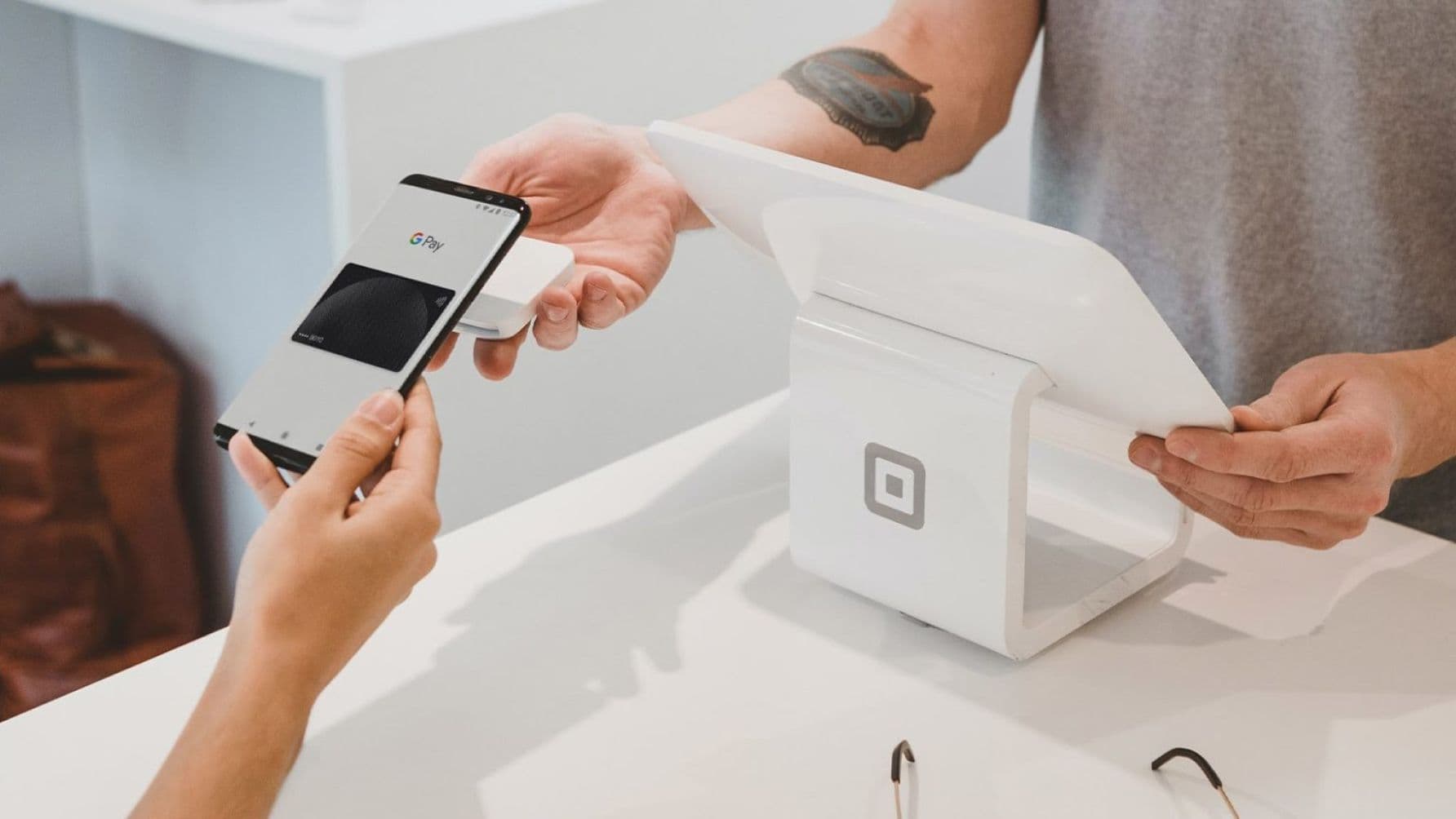 Two people using a phone scanner to make a transactions with google pay by