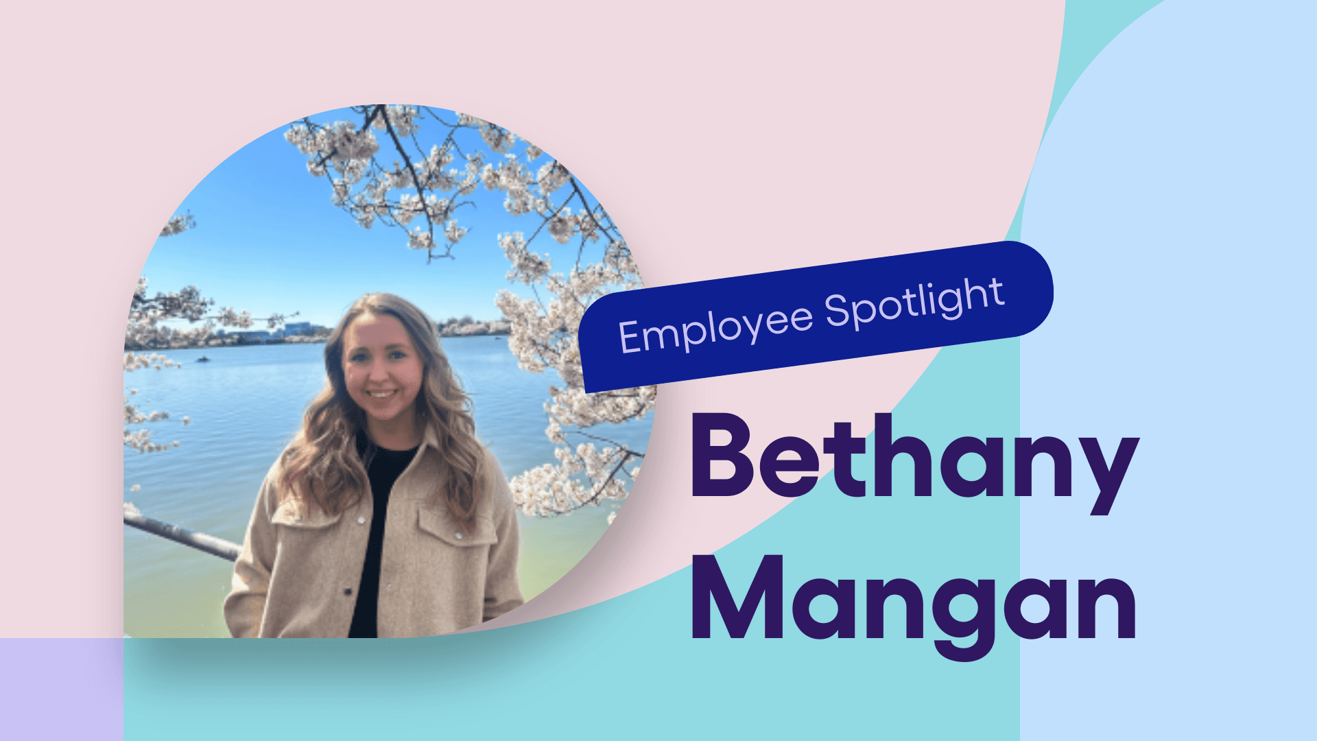 Bethany Mangan smiles in front of cherry blossoms at a lake.