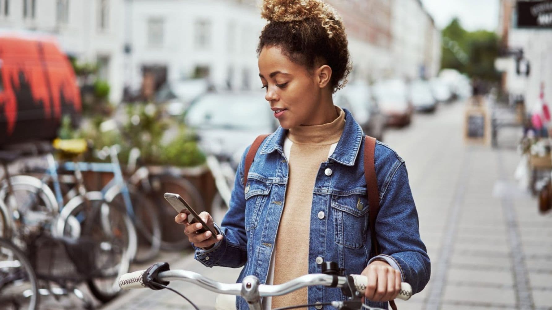 A lady on a bicycle using a smart phone