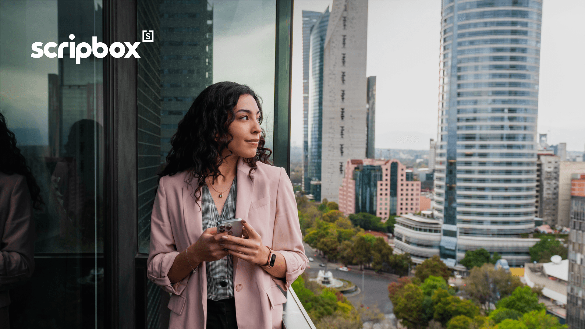 Woman on balcony looking at city with scripbox logo in the top left corner