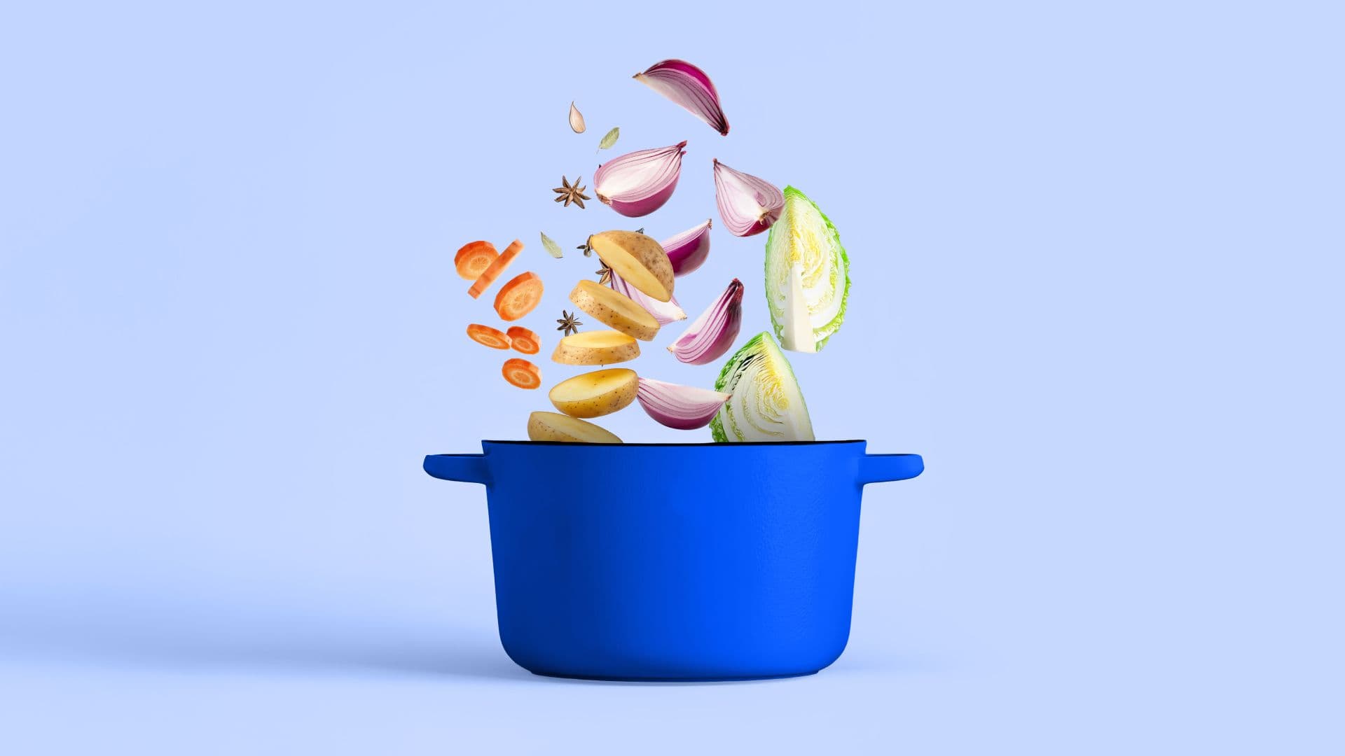 Sliced vegetables going into a blue pot