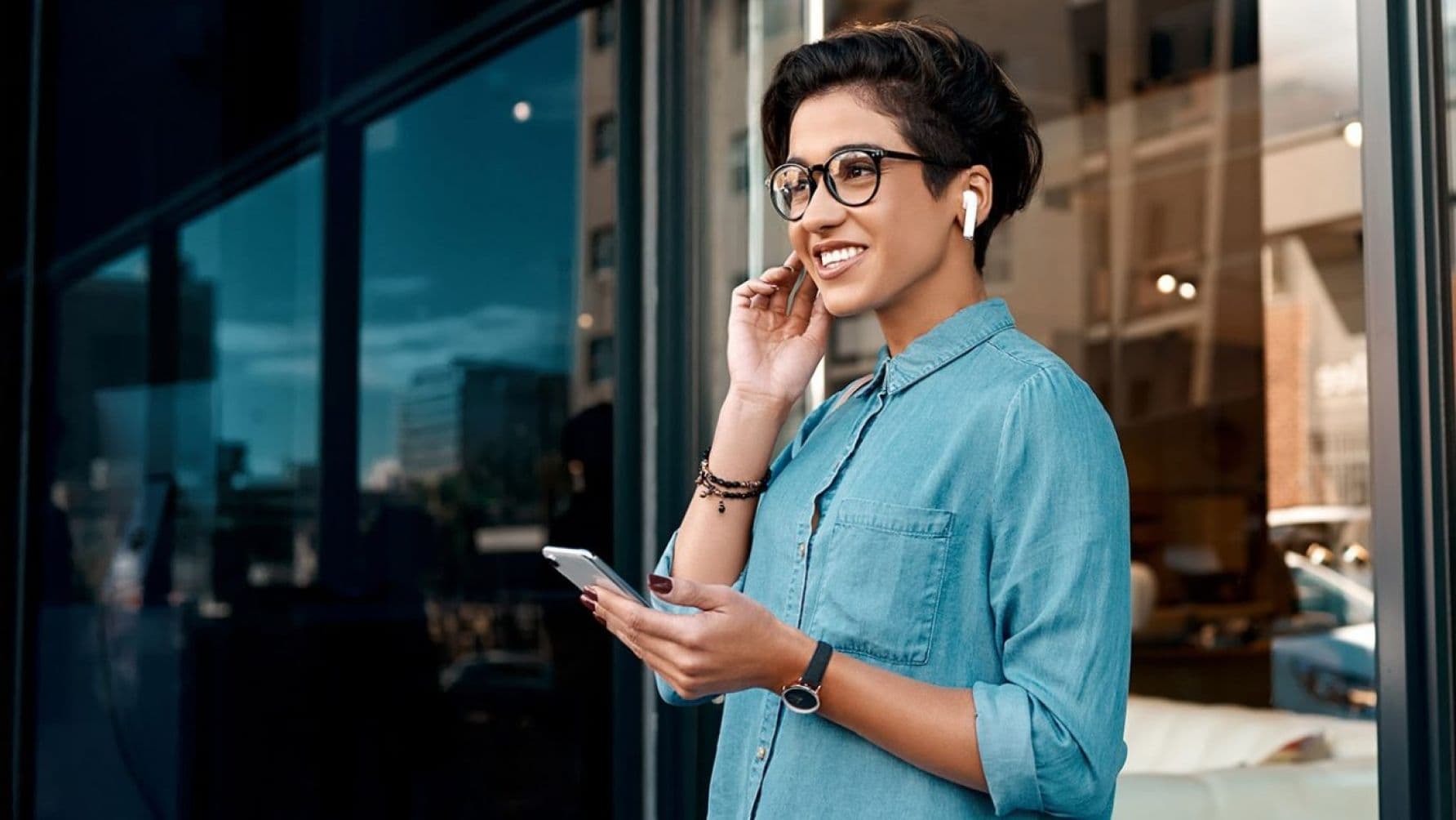 A lady holding a phone looks excited
