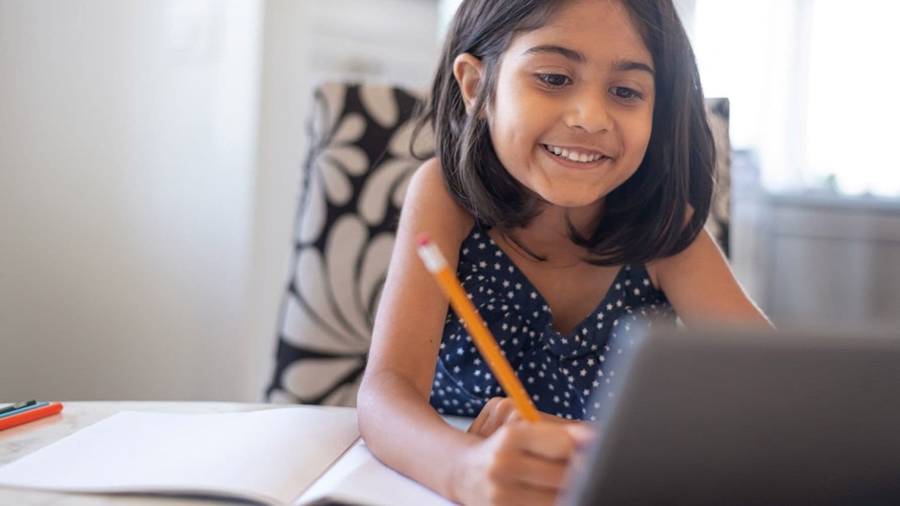 girl holding a pencil looks happy