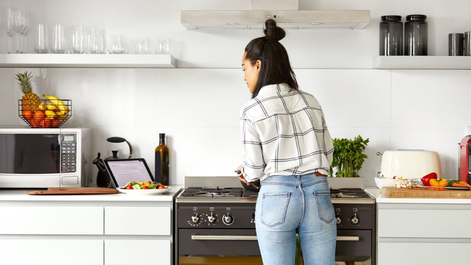 lady in the kitchen cooking while watching on a tablet